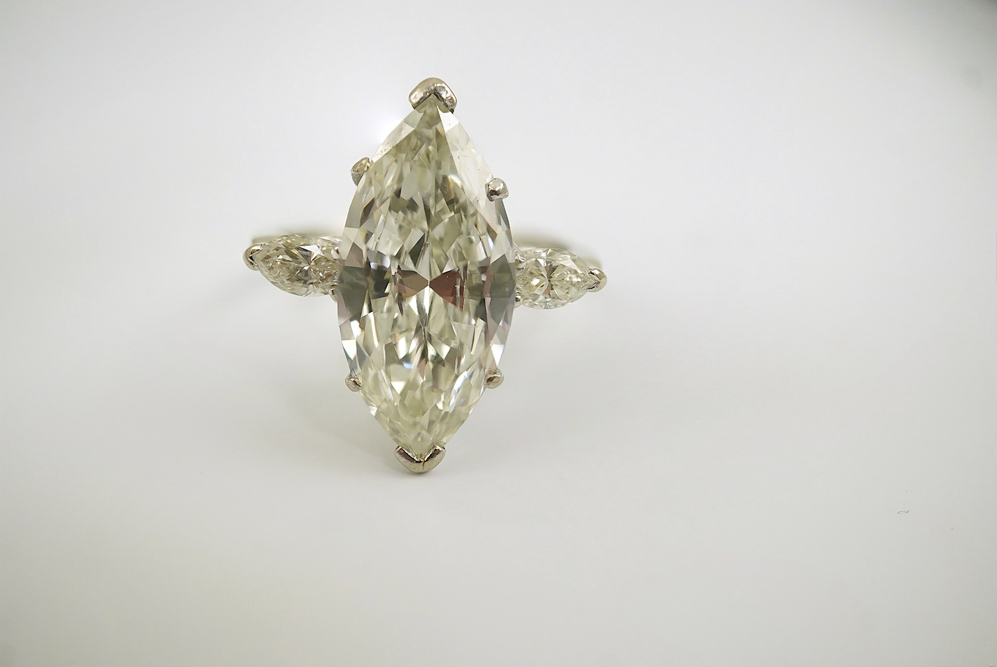 A modern 18ct white gold and single stone marquise cut diamond set ring, with two stone marquise cut diamond set shoulders